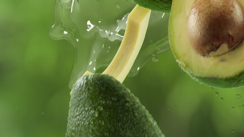 Avocado with Slices and Splash Falling on Garden Background