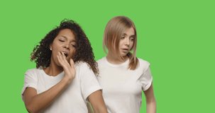 two attractive girls dancing on chroma key background . Happy women having fun on a Green Screen, 4k video footage slow motion 60 fps