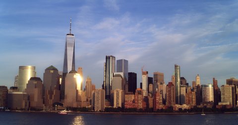 Aerial view of Manhattan skyline skyscrapers from water in New York at golden hour. Wide to Long shot on 4K RED camera.