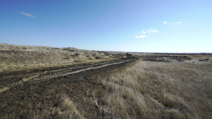 Farm truck slides around on muddy gumbo farm ranch road on ranch road