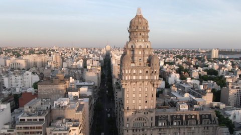 Montevideo, Uruguay - December 01, 2019: Aerial jib shot of Montevideo cityscape showing historical landmarks Palacio Salvo and Independence Square at sunset. 