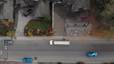 A white SUV limosine pulls up outside a house in an affulent neighborhood to pick up a woman waiting outside. 4K 24FPS.