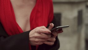 Hands Of Girl Using Mobile Phone. Girl In Red Dress With Open Neckline.