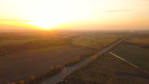 4K Aerial. Fly over highway with cars in rural area. Sunset time

