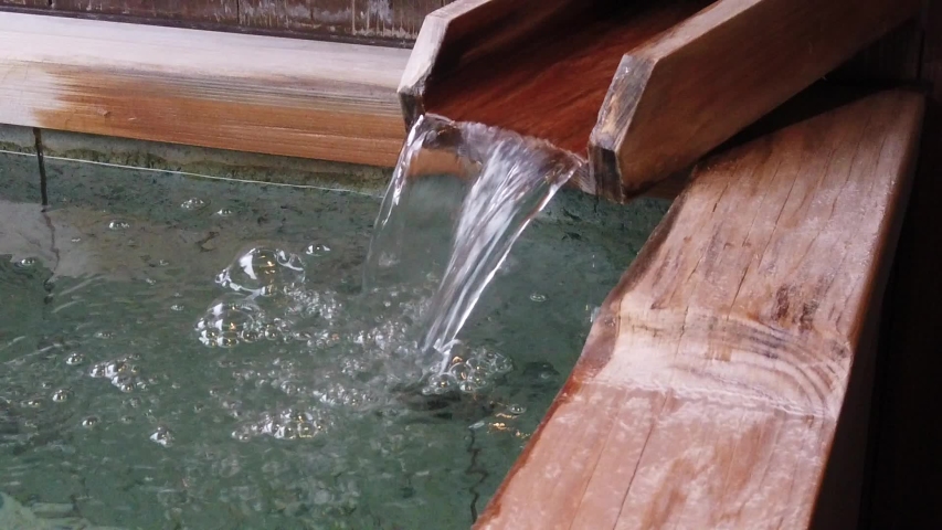 Hot spring water flowing into a Japanese open air onsen. Slow motion HD video