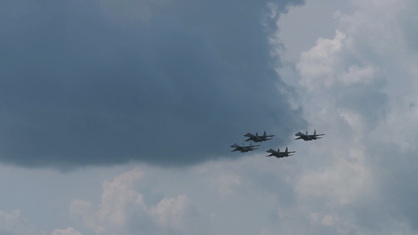 Supersonic fighter jets team in formation flying in the sky. Military aviation