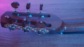 Closeup back of an accoustic guitar travelling, blue and purple colors in background - Powered by Shutterstock - Get 15% off with code: PIKWIZARD15