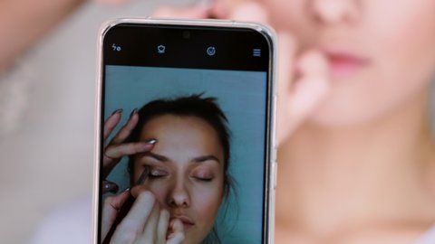 Record video on your smartphone for a beauty blog. Makeup artist and blogger make a video lesson about makeup