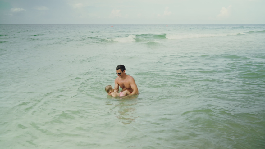 Happy father and his adorable little baby girl at the Panama City Beach having fun