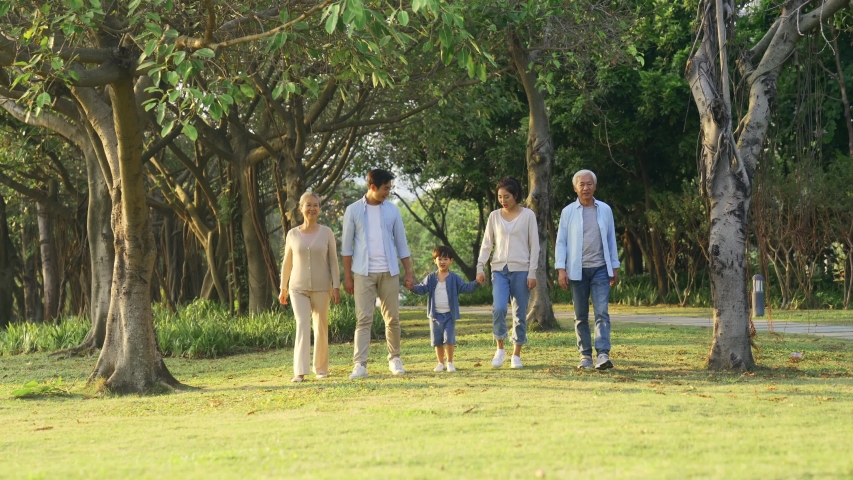 three generation asian family walking talking relaxing outdoors in park