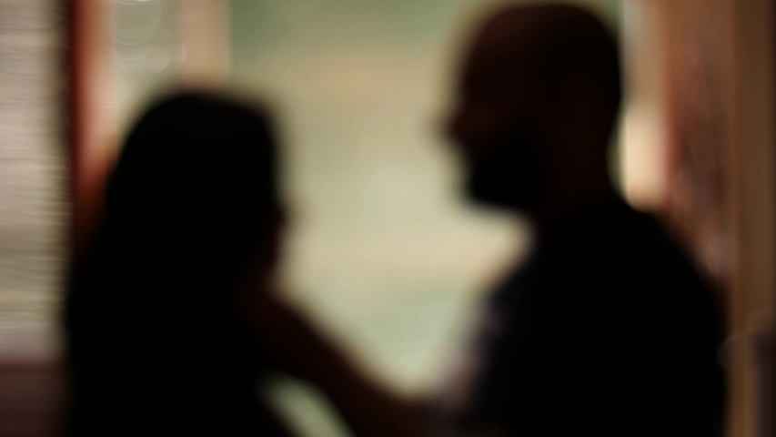 Medium closeup silhouetted and blurred view of a man choking a woman. Domestic violence. Husband beating his wife. | Shutterstock HD Video #1045750300