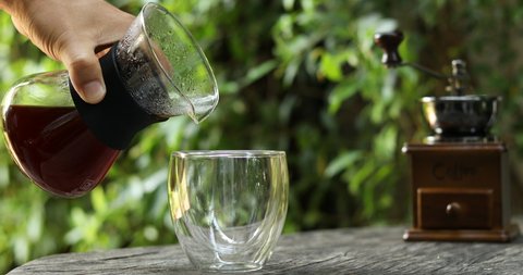 Hands pouring drip coffee, hand drip coffee with natural background, pouring coffee into glass on table,Espresso – Video có sẵn