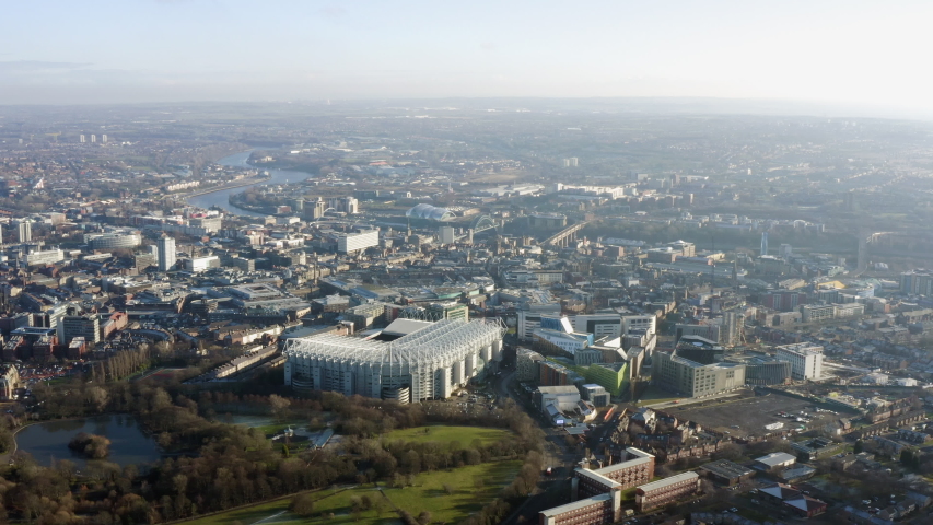 Newcastle upon Tyne aerial view, known as Newcastle, is a city in Tyne and Wear, North East England. Flying above the city ft. St James Park football stadium, park, river and central buildings in UK Royalty-Free Stock Footage #1045761364