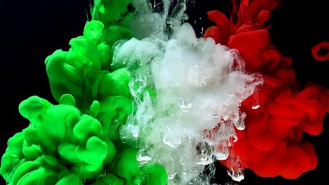 Flag of Italy from colored ink on a black background. Stylish abstract modern background. Green, white and red watercolor ink in water. A powerful explosion of colors. Cool trending screensaver.