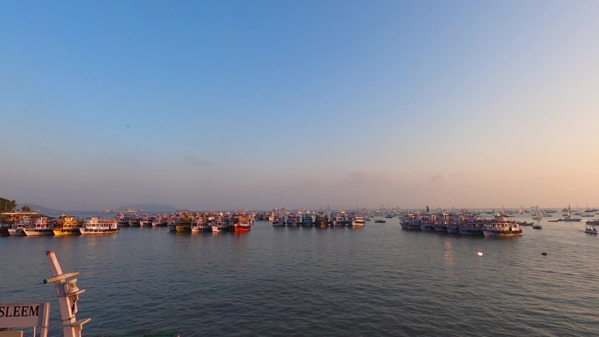 Real time footage of Ferry boats, yachts and ships in the sea near popular tourist attraction Gateway of India, Mumbai during sunset. 