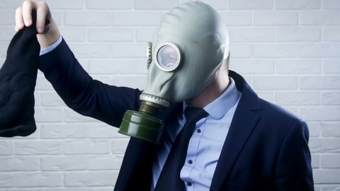 Businessman with gas mask is holding stinky sock - unpleasant smell concept