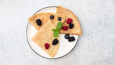 Stop Motion Animation French Crepes With Berries Or Russian Blini Folded On Plate. Top View