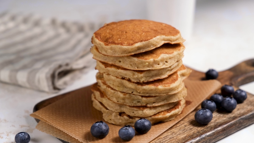 Pancakes with maple syrup and blueberries. Stack of whole grain oat pancakes. Tasty breakfast 4K footage Royalty-Free Stock Footage #1045776634