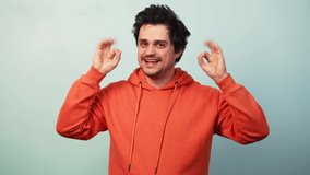 Guy show approval gesture on blue background