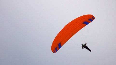 man on a parachute flies over the mountains
