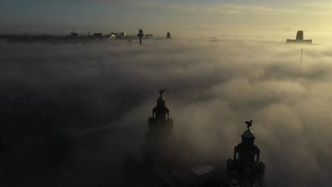 Misty foggy flyover of a northern town. Watch the sunrise and cut through the mist in this dramatic aerial footage