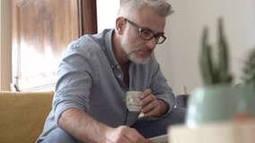 Man at home sitting in sofa having hot coffee