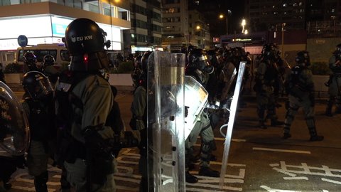 HONG KONG, 7 OCTOBER 2019: Riot police officers in full gear prepare to move in on demonstrators at night near Prince Edward MTR station in Hong Kong, during violent protests in Kowloon district
