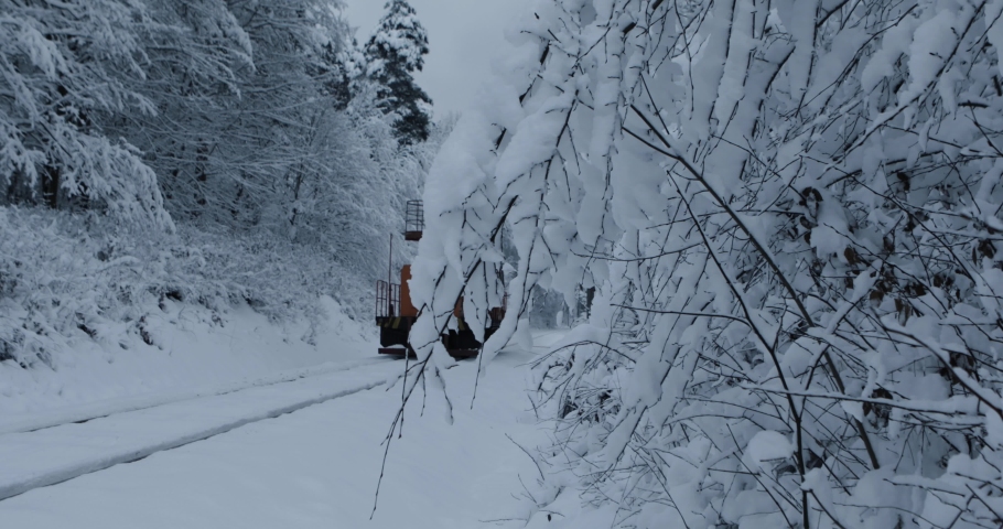 Repair of the railway in winter. 
Special equipment for repair of the railway. Special train in the forest. Winter railway. Snowy weather. Trees in winter. 