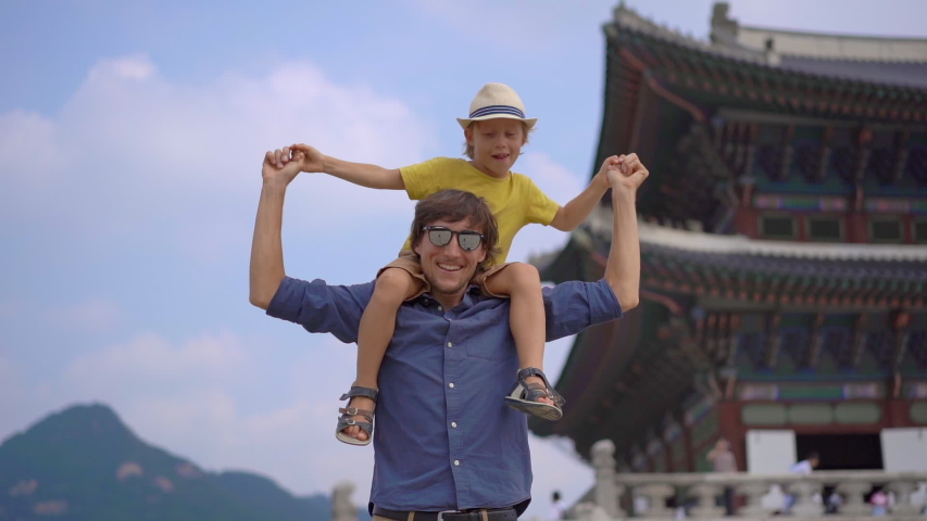 Young man and his little son visit ancient palace in Seoul, South Korea. Travel to Korea concept. Slowmotion shot