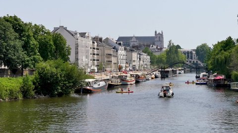 Nantes is the capital of the Pays de la Loire Région in northwestern France, on the Loire River. View of the erdre river in Nantes, in the west of France. Boats on the water, filmed in summer.