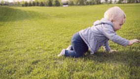 Toddler girl playing outdoor, spending day on green lawn in park