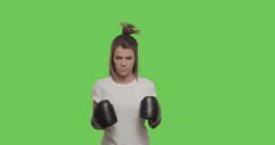 Caucasian female looking at camera. Sporty girl training fighting, boxing, exercising for self-defense over Green Screen, Chroma Key. 4k raw video footage slow motion 60 fps