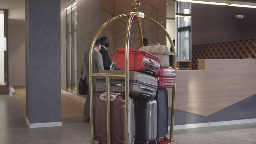Tracking shot of luggage trolley full of suitcases in lobby of luxurious hotel Royalty-Free Stock Footage #1045882201