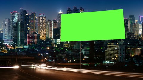 Time Lapse of Blank Billboard with a Green Screen on Night Street with light trails, city night background.	