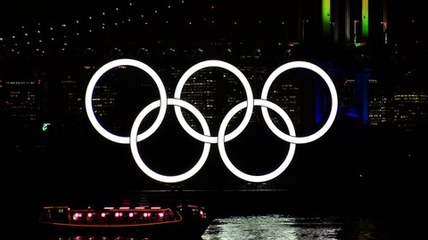 TOKYO, JAPAN - 25 JAN 2020 : The five ring symbol of the Olympic Games in front of Odaiba Rainbow Bridge. Japan will host the Tokyo 2020 summer Olympic and Paralympic. Shot in night light up time.