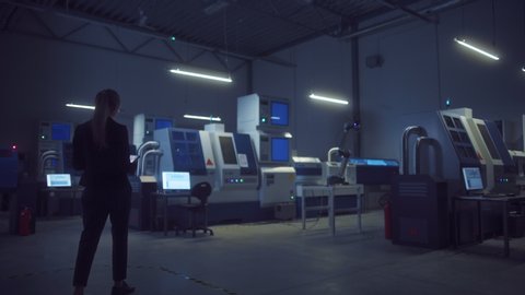 Industry 4.0 Modern Manufacturing Factory Lights Turning On: Female Chief Engineer and Sole Operator Enters Fully Automated Workshop with Contemporary CNC Machinery and Assembly Line robot arm