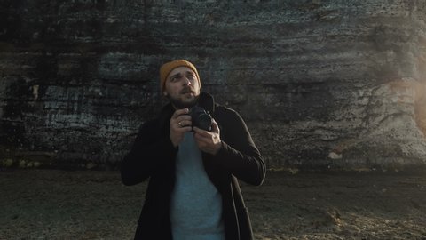 Excited male photographer taking photos of amazing rocky Normandy beach near sunny Etretat seaside cliffs slow motion. Stock-video