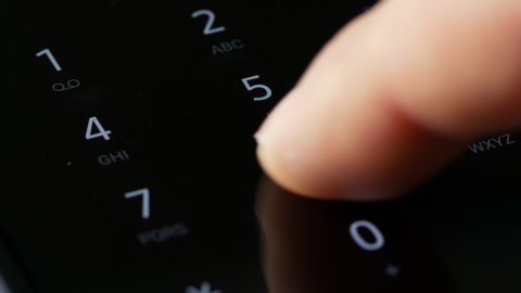 close up finger dialing pin or phone number on digital keyboard screen