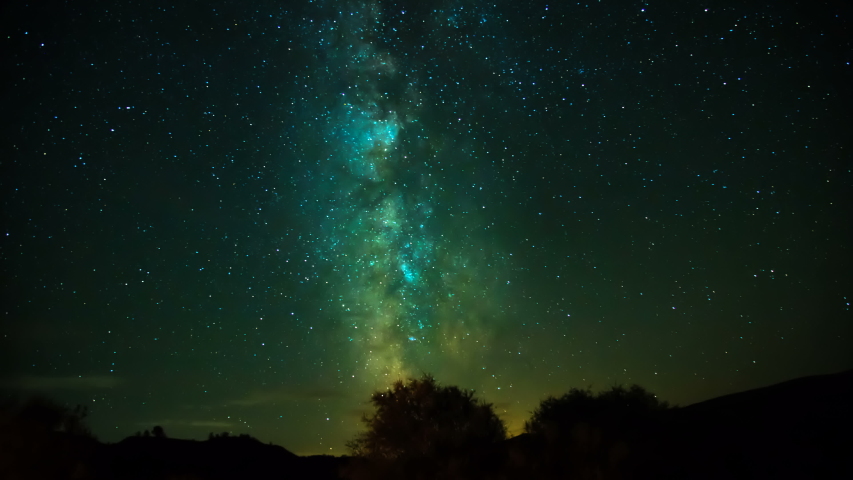 The motion of the Milky Way in the night sky. Clouds cover the sky illuminated from below. 4K Timelapse