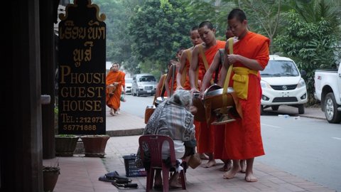Luang Prabang / Laos - 03 04 2019: Alms giving in Luang Prabang, religious ritual, collecting food