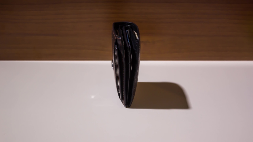 Coins appear in stop motion in front of the wallet