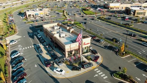 Lancaster , PA / United States - 10 28 2019: Aerial tilt up reveals Chick-fil-A two lane busy drive through, American flag