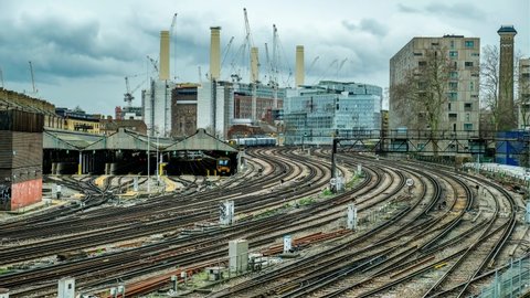 LONDON- FEBRUARY, 2020: Time lapse of trains leaving and arriving from Victoria Station with Battersea Power Station construction site in background