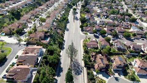 Aerial view of small road in typical suburban neighborhood with big villas next to each other during sunny day, San Diego, California, USA. Aerial view of residential subdivision house