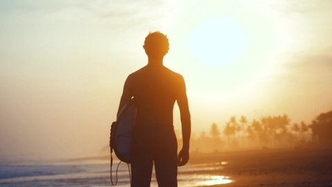 SLOW MOTION Evening at the beach adventure travel surfing male at sunset