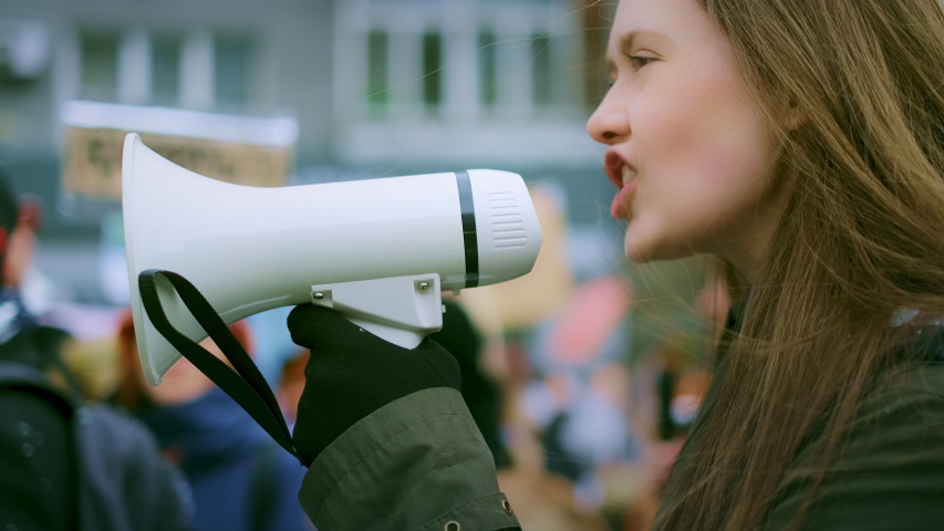 Young adult female feminist demonstration. Gender rights feminism fight. Women march movement power sign equality. Gender woman strike empowerment action. Social message. Crowd people city street day. Royalty-Free Stock Footage #1045954444