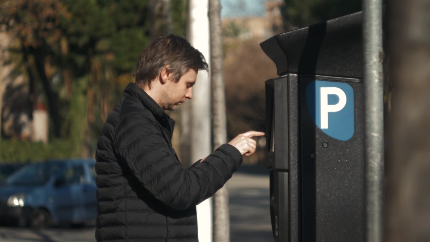 man inserting a parking lot ticket at an automated pay machine pay with card. Cash Automated machines parking lot in city attendants.