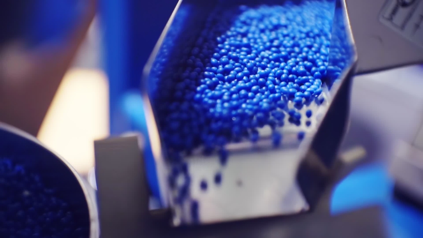 Modern production.plastic processing and production.round blue plastic granules move along the production line.macro shooting.close-up.shallow depth of field | Shutterstock HD Video #1045984762