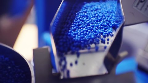 modern production.plastic processing and production.round blue plastic granules move along the production line.macro shooting.close-up.shallow depth of field