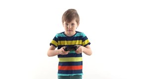 little boy in the studio on a white background plays the joystick in video games